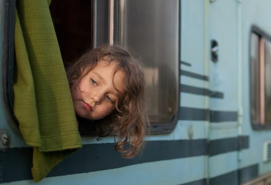 Little girl looking out from camper van